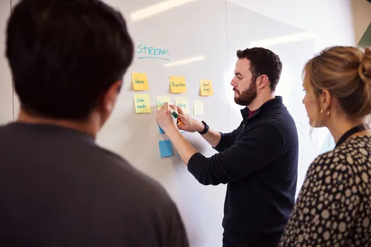 Kevin leading a product strategy session with sticky notes on a whiteboard
